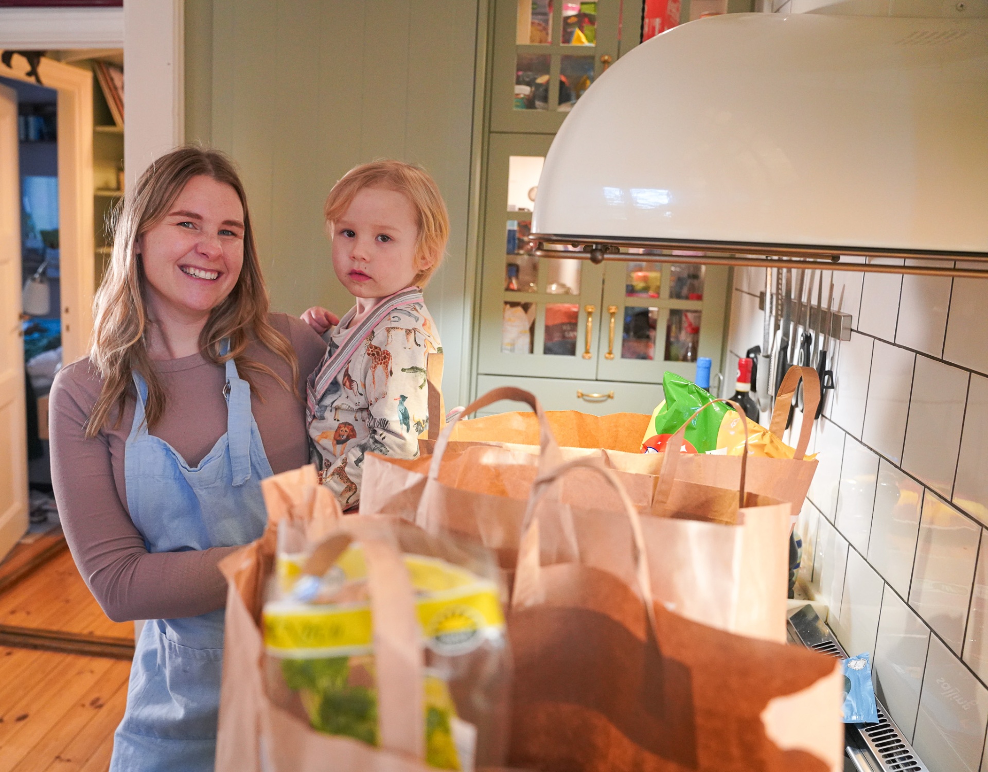 Mamma och barn med matkassar
